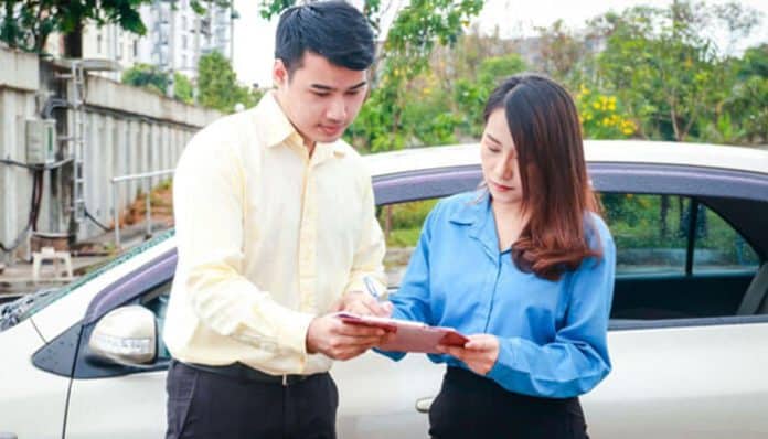 Man and woman reviewing documents beside a car, discussing four wheeler insurance costs for better financial planning