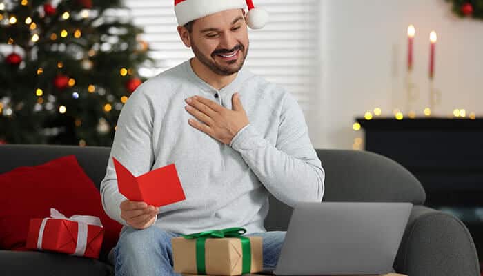 Emotional Christmas Email Campaigns showing a man reading a heartfelt holiday message on a laptop at home