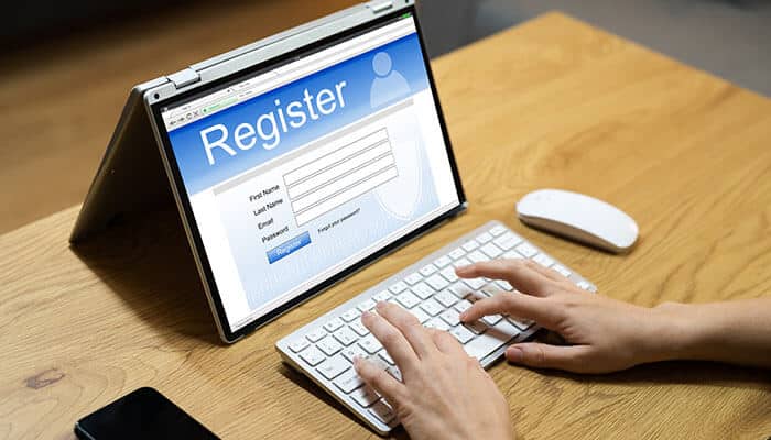 A person typing on a laptop with a registration form open, symbolizing the process of registering a private number plate online.