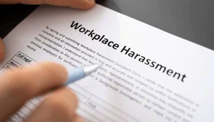 Workplace Harassment policy document being reviewed and signed, highlighting employee rights and legal protections at work