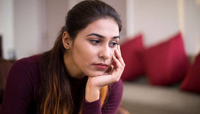 Why People Stay Silent - Startupeditor | Startup Editor Workplace Harassment impact shown through a stressed employee sitting alone, reflecting emotional distress caused by a hostile work environment