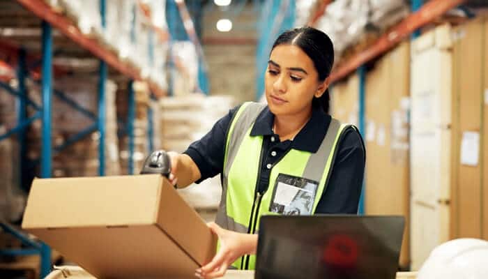 Barcode Inventory System in action with employee scanning a package to update inventory records accurately.
