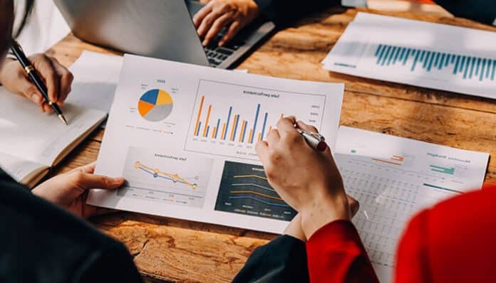 Year-Round Financial Strategy illustrated through business professionals reviewing financial charts, reports, and performance data.