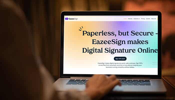 Person using a laptop to access EazeeSign digital signature solution website for secure document signing and online business management