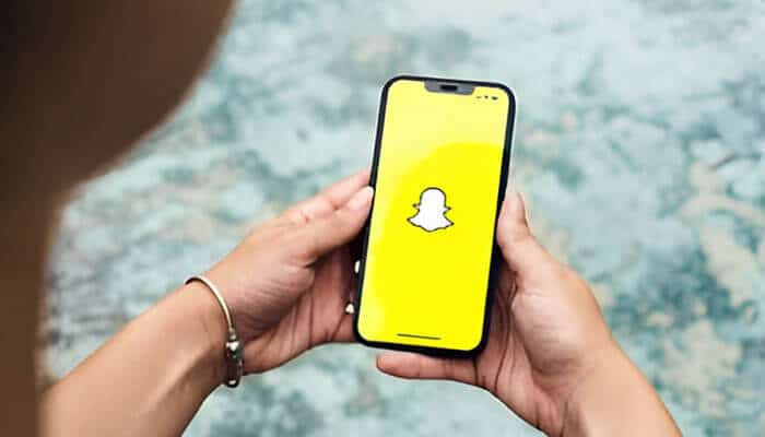 Snapchat logo displayed on a smartphone, showcasing the app's yellow background and icon, related to learning how to see who screenshotted your public Snapchat story