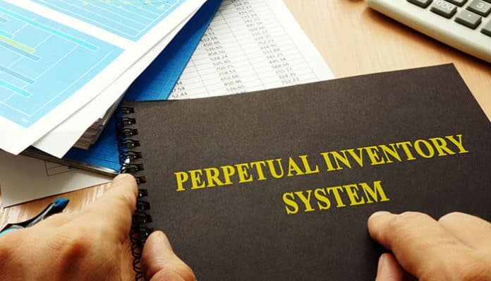 Perpetual Inventory System book with financial documents on desk