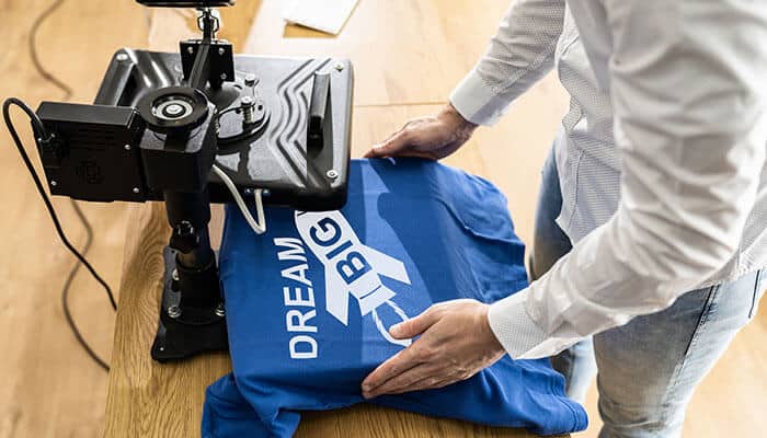 Person using a print-on-demand machine to create custom t-shirts, an innovative online business ideas for creators