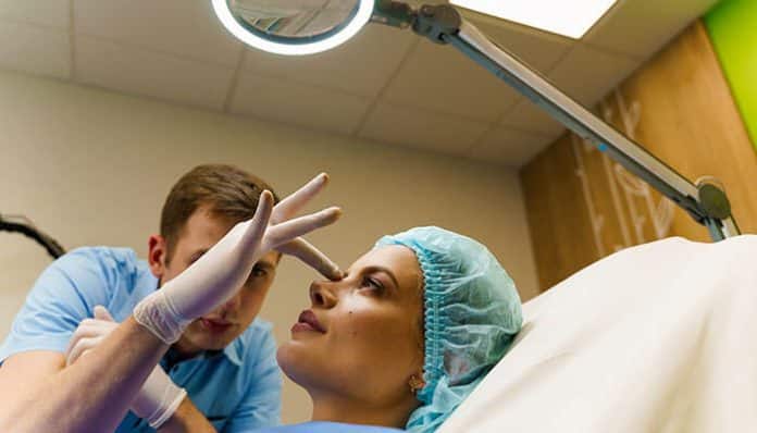 Choosing Rhinoplasty Surgery shown through a surgeon consulting a patient before a nose reshaping procedure in a clinical setting.