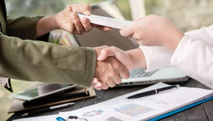 Business professionals exchanging documents, illustrating the process of using debit note and credit note for financial adjustments in transactions