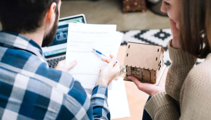Shellpoint Mortgage - Startup Editer | Startup Editor A couple reviewing their mortgage application form, with one holding a miniature house model, as they consider services from Shellpoint Mortgage in their home-buying journey. What will Shellpoint do in mortgage servicing?
