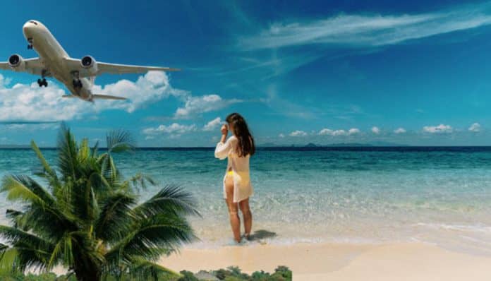 Air Transat Tout Inclus vacation scene showing a traveler standing on a tropical beach watching an airplane fly overhead, representing seamless all-inclusive travel packages that combine flights, luxury beach destinations, and stress-free holiday planning for modern travelers.