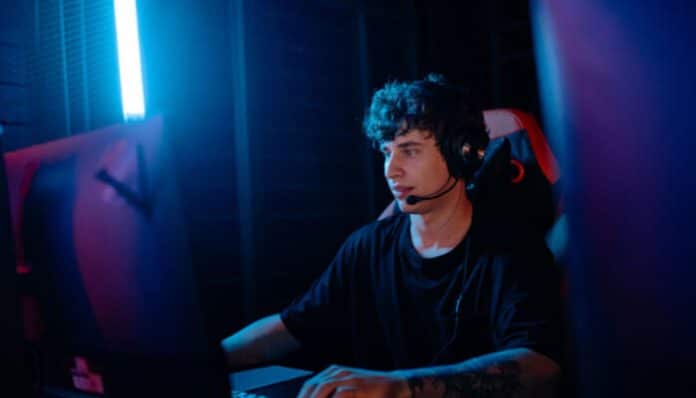 Professional esports gamer competing in a neon-lit high-performance setup during the Best Online Gaming Event TheHakevent, highlighting intense online tournament gameplay, headset communication, and competitive digital esports atmosphere.
