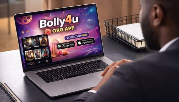 A person using a laptop with the Bolly4u Org App interface displayed, showcasing movie options and download buttons for Android and iOS devices.