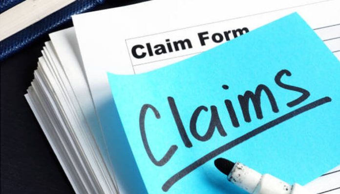 Claim form with 'Claims' written on a sticky note, representing the process to file a claim without a police report