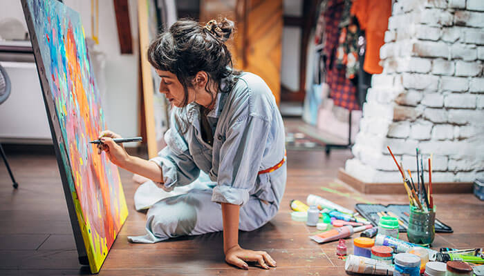 How Artists Should Measure Success by Goal - Satrtupeditor | Startup Editor How Do Artists Use Social Media? An artist painting on a canvas in a studio, using social media to document and share their creative process with their followers