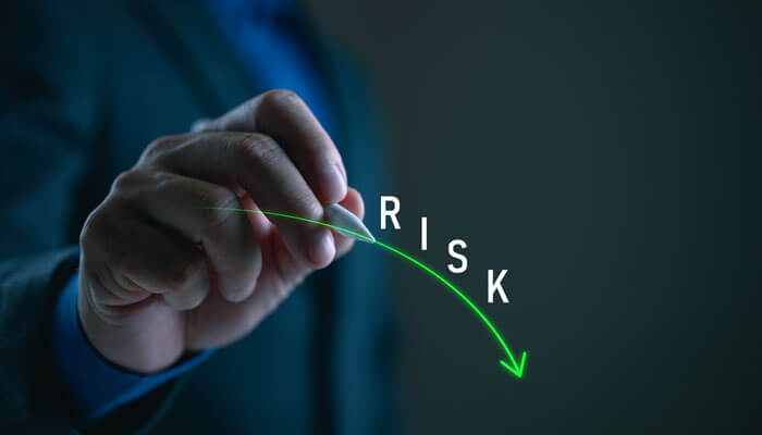 Why This Method Reduces Risk - Startupeditor | Startup Editor What is one way for an entrepreneur to decrease risk? Hand drawing a downward green arrow labeled "RISK" representing strategic planning to reduce business risk.