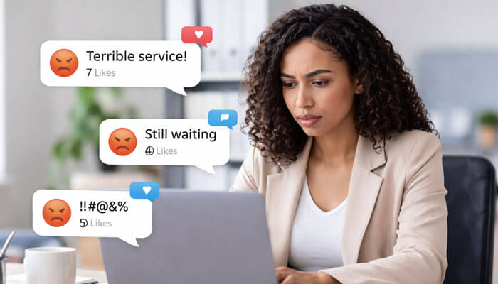 Not All Negative Comments Are the Same - Startupeditor | Startup Editor Professional working on a laptop while managing customer complaints, showing how to handle negative comments on social media effectively