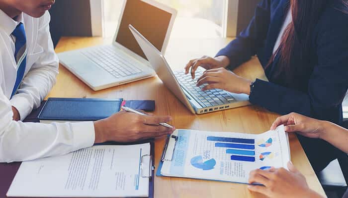 Streamlining Business Operations - Startupeditor | Startup Editor Business professionals reviewing printed analytics and digital records while using Intelligent OCR to automate document data extraction.
