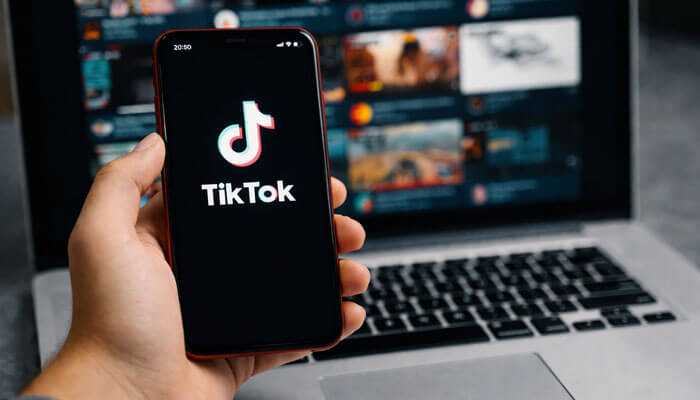 TikTok - Startupeditor | Startup Editor How to Use Content Curation on Social Media shown with a smartphone and laptop displaying social media content discovery and sharing workflow.