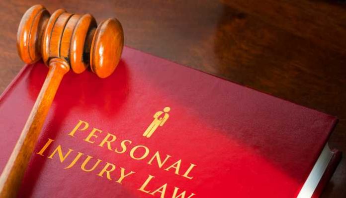Gavel resting on a red law book titled 'Personal Injury Law'.