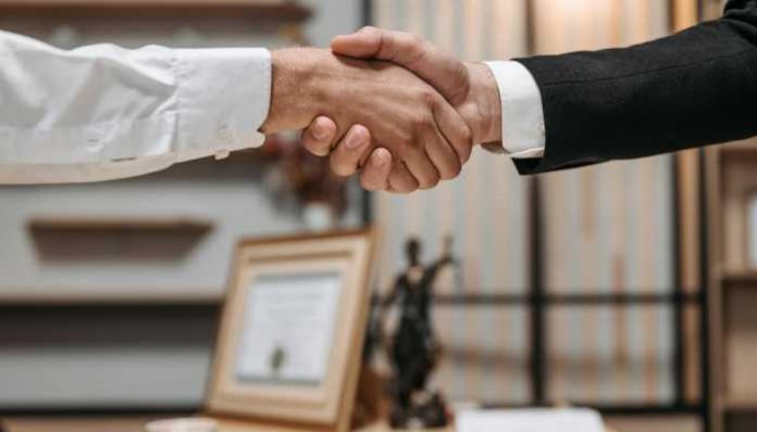Business professionals shaking hands during a workplace agreement related to employment law for startup founders