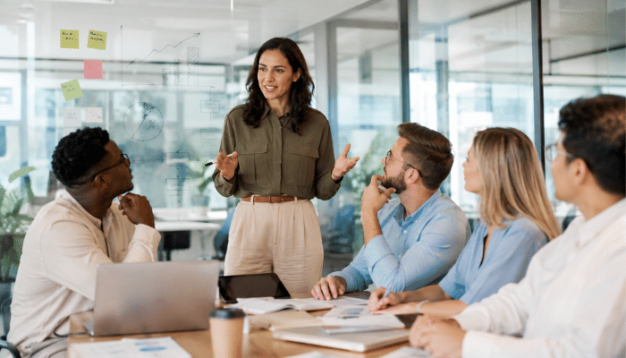 What Is Transformational Leadership | Startup Editor Servant Leadership vs Transformational Leadership shown through a business leader guiding a team discussion in a modern office.