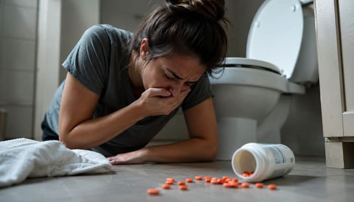 What Happens If You Take Too Much Ibuprofen - Startupeditor | Startup Editor Woman feeling sick beside spilled tablets, illustrating the dangers of exceeding the maximum dose of ibuprofen in 24 hours.