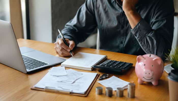 When Investing May Not Be the Immediate Priority - Startupeditor | Startup Editor Which reason to invest resonates the most with you? Why? A person reviews bills, savings, and expenses before making investment decisions.