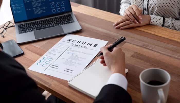 Emerging Business Systems Analyst Resume Keywords for 2026 - Startup Editor | Startup Editor Business Systems Analyst Resume Keywords in practice as a recruiter reviews a candidate resume alongside analytics software during the hiring and screening process.