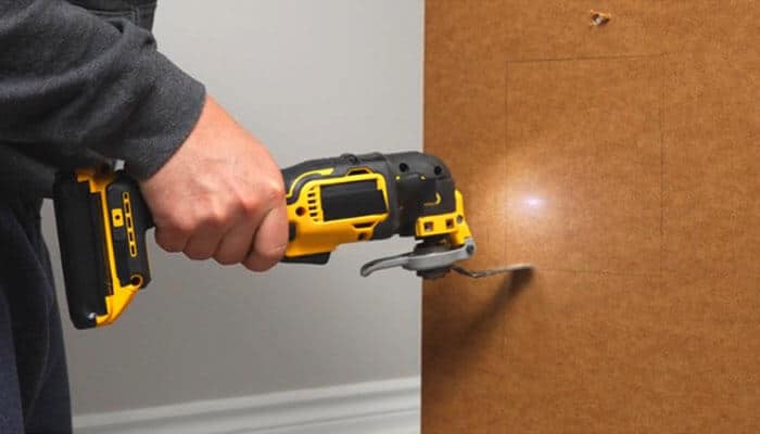 Which Battery Is Best for a DEWALT Oscillating Multi Tool? - Startup Editor | Startup Editor DEWALT Oscillating Multi Tool Review demonstrating the DCS356 performing a controlled plunge cut into wood, emphasizing variable-speed trigger control, precision cutting, and versatility for carpentry and renovation work.