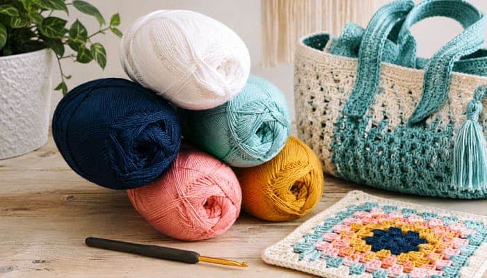 What Is Lion Brand 24 Cotton Yarn - Startupeditor | Startup Editor Lion Brand 24/7 Cotton Yarn in multiple colors with crochet bag, granny square, and hook.