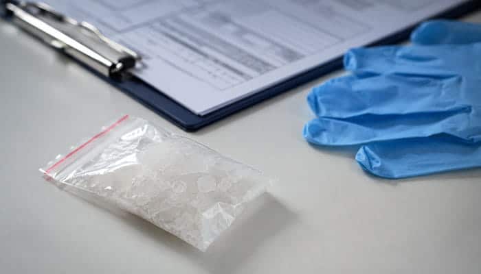 What Is Methamphetamine - Startupeditor | Startup Editor How Long Does Meth Stay in Your System for Urine Sample with suspected methamphetamine crystals, gloves, and laboratory paperwork.