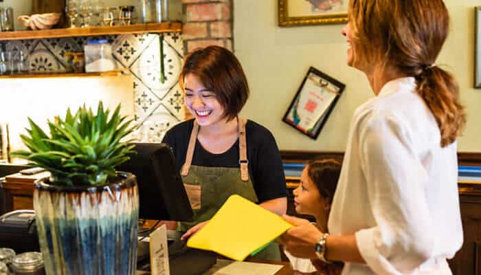 How to Support New Local Businesses Early - Startup Editor | Startup Editor Best Ways to Support Local Businesses with customers interacting at a local store, highlighting personal service, trust, and community relationships.
