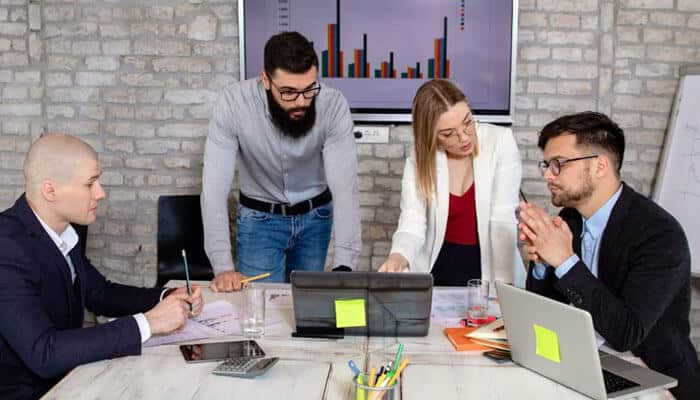 Startup Booted Is Also a Publishing Platform - Startup Editor | Startup Editor Startup Booted business team analyzing financial charts, startup projections and fundraising plans during a collaborative office meeting.
