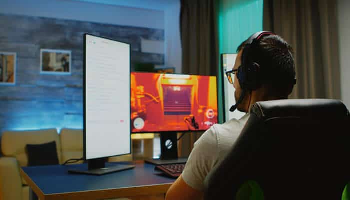 Why Information About LyncConf Game Mods Can Be Confusing - Startup Editor | Startup Editor LyncConf Game Mods research setup with a PC gamer using multiple monitors to explore gaming modifications and compatibility guides.