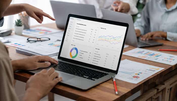 How to Analyze Competitors in AI Search in 2026 - Startup Editor | Startup Editor Best Free Competitor Analysis Tools in 2026 displayed on a laptop during team research with keyword data, traffic trends, charts, and SEO reports.