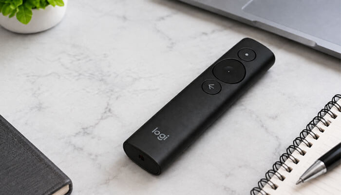 Detailed Reviews of the Best Wireless Presentation Clickers - Startup Editor | Startup Editor Logitech wireless presentation clicker beside a laptop and notebook on an office desk