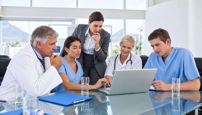 How Multispecialty Care Works at Springhill Medical Group - Startup Editor | Startup Editor Springhillmedgroup Team Guide showing healthcare specialists collaborating during a medical discussion about patient care, diagnosis, and healthcare solutions.