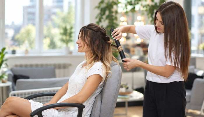 Why Is Money Piece Hair So Popular? - Startup Editor | Startup Editor Money Piece Hair coloring process showing a stylist creating face-framing highlights with professional hair styling techniques for a fresh salon look.