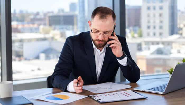 How Often Can Midland Credit Management Call? - Startup Editor | Startup Editor Midland Credit Management debt assistance scenario showing a person discussing collection concerns, account verification, and repayment solutions with financial documents.