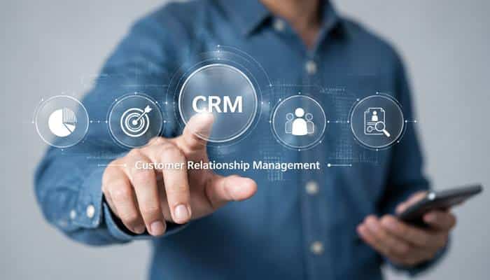 Key Benefits of CRM - Startup Editor | Startup Editor What Is Customer Relationship Management (CRM)? Businessperson using a digital CRM interface for customer data, sales analytics, and lead management.