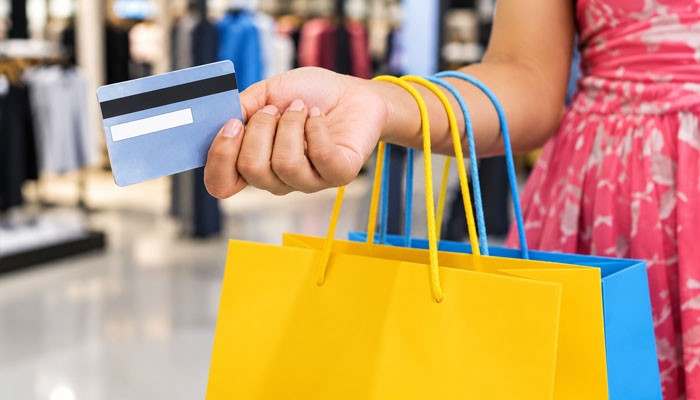 What Happens If a Marshalls Gift Card Is Lost or Stolen? - Startup Editor | Startup Editor Close-up of a shopper holding a Marshalls Gift Card with colorful retail shopping bags inside a clothing store.