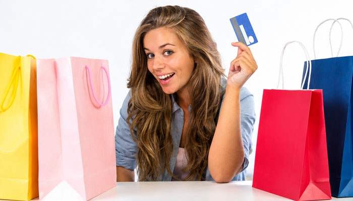 How to Check a Marshalls Gift Card Balance - Startup Editor | Startup Editor Shopper holding a Marshalls Gift Card while surrounded by colorful shopping bags, representing convenient gift-card shopping.