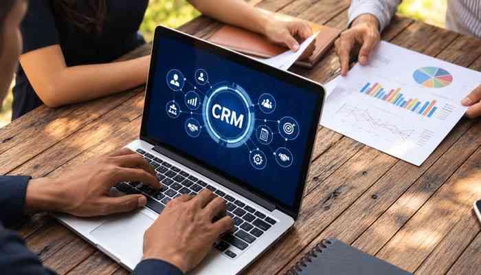How Much Does CRM Software Cost? - Startup Editor | Startup Editor What Is Customer Relationship Management (CRM)? Business team using CRM software on a laptop to analyze customer data, sales performance, and reports.