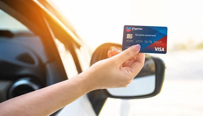 Can You Combine Chevron Rewards With the Credit Card? - Startup Editor | Startup Editor Hand holding a Chevron Credit Card Techron Advantage Visa outside a vehicle, illustrating credit card benefits and rewards for eligible fuel purchases.